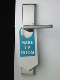 Close-up of signboard hanging on door handle
