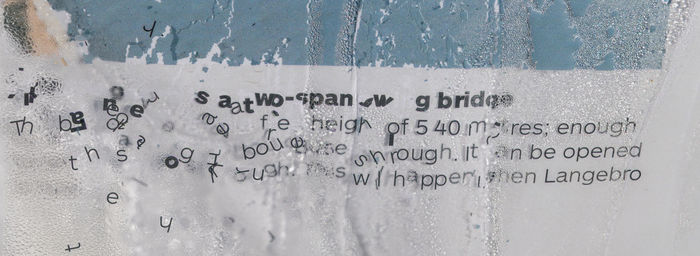 Close-up of text on glass wall