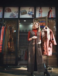 Full length of woman standing against store