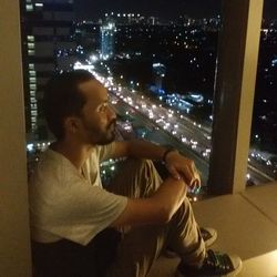 Side view of man looking at illuminated camera