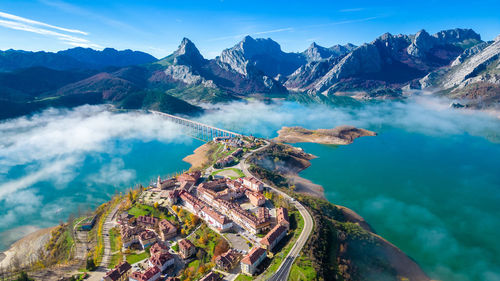 Aerial view of townscape and mountains against sky