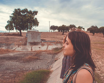 Side view of woman wearing sunglasses against sky