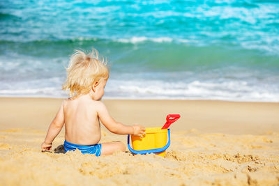 Rear view of boy playing on beach