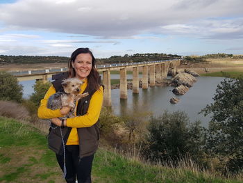 Portrait of woman with dog against sky