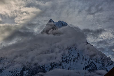 Low angle view of snowcapped mountain against sky