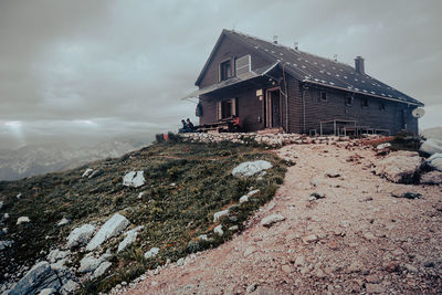 Panoramic shot of cottage on mountain against sky