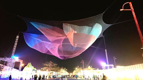 Illuminated hot air balloons in sky at night
