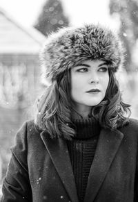 Close-up of young woman in warm clothing standing outdoors