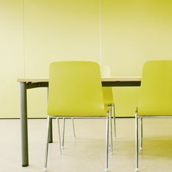 Table with yellow chairs against wall