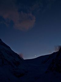 Low angle view of snowcapped mountains against sky at night