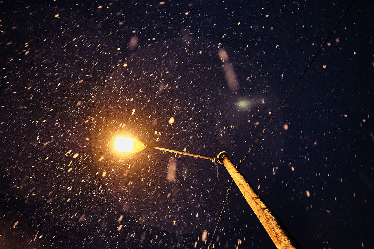 ILLUMINATED STREET LIGHT AGAINST SKY DURING WINTER