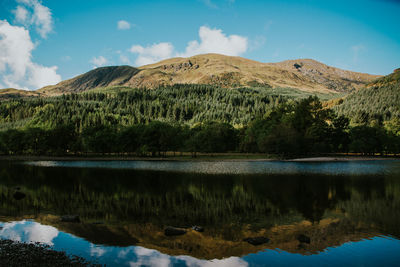 Scenic view of lake by mountains against sky