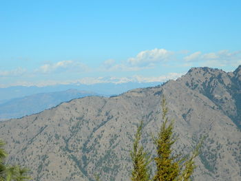 Scenic view of mountains against blue sky