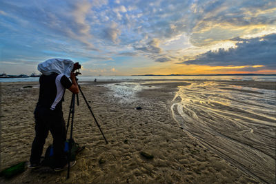 Side view of a photographer at calm beach