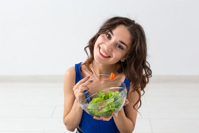 Portrait of a smiling young woman holding ice cream