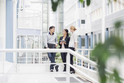 Business people communicating at office balcony