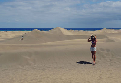 Full length of woman standing on desert