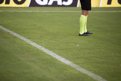 Low section of man standing on field