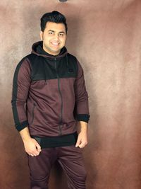 Portrait of young man standing against wall