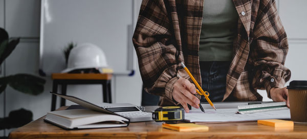 Midsection of man working with book on table