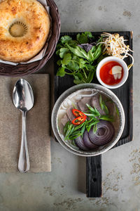 Vietnamese pho bo soup with beef hot peppers, lots of greens and bread tortilla. asian food