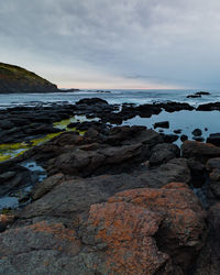 Rocks on beach against sky