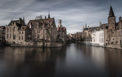 River by buildings against sky