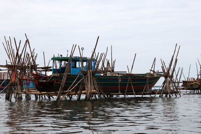 Boat under repair supported on bamboo scaffolding at andoung tuek floating village, cambodia