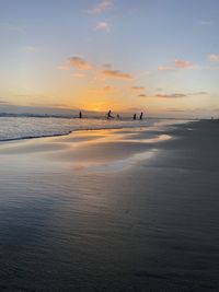 Scenic view of beach against sky during sunset