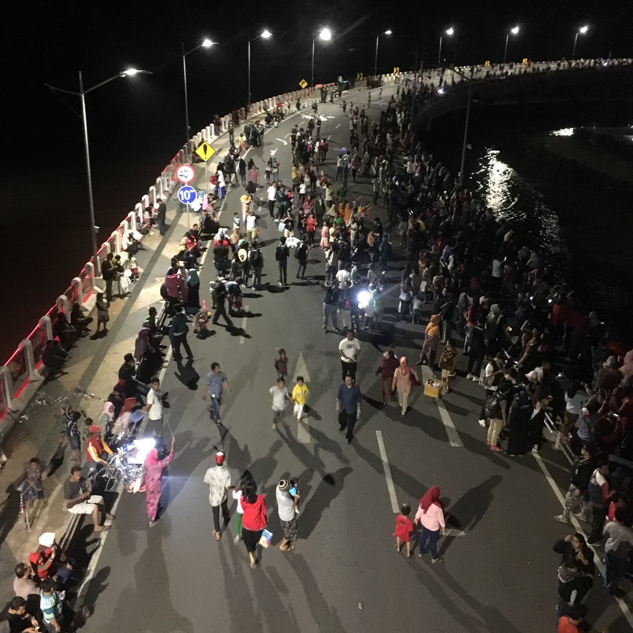 HIGH ANGLE VIEW OF PEOPLE ON ROAD