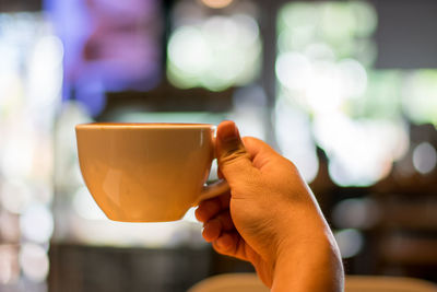 Close-up of hand holding coffee cup