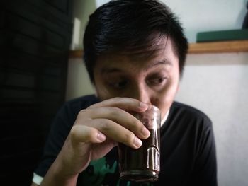 Portrait of young man drinking glass of coffee