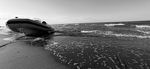 Boat on sea shore against sky