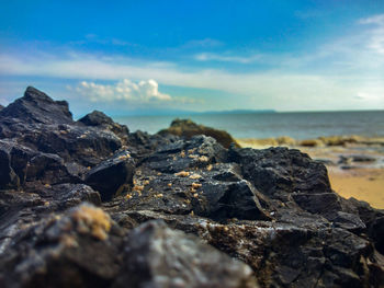 Scenic view of rocks on beach against sky