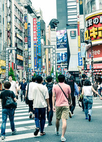 Rear view of people walking on city street