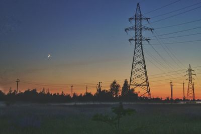 Silhouette electricity pylon against sky at sunset