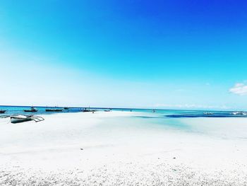 Scenic view of beach against blue sky