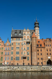 Buildings in city against clear blue sky