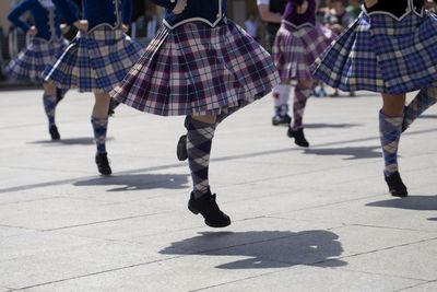 Low section of women dancing on footpath