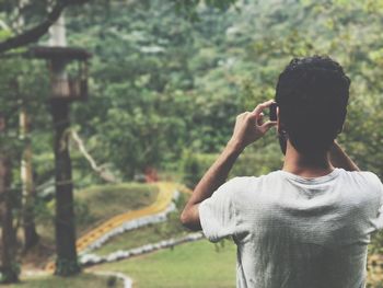 Rear view of man photographing at park