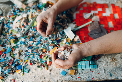 Copped hands of artist holding mosaic