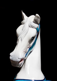 Close-up of a horse statue against black background