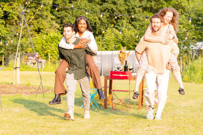 Portrait of happy friends standing on field