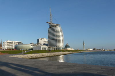 Buildings in city against clear blue sky