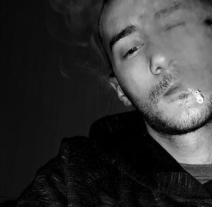 Close-up portrait of young man smoking