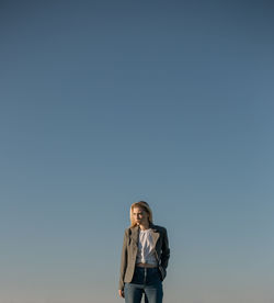 Woman standing against clear blue sky