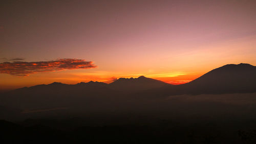 Colorful sunrise on top of kelud mountain with view kawi mountains