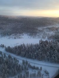 Scenic view of snow covered landscape against sky during sunset