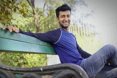 Portrait of smiling young man sitting outdoors