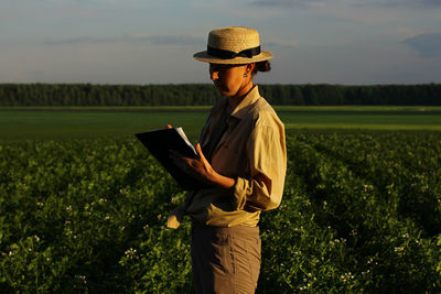 The farmer controls the quality of the potato crop. female agronomist in agriculture